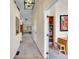 Inviting hallway with neutral colors, a decorative mirror and an open doorway to an office space at 7809 S Flower St, Littleton, CO 80128