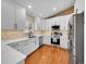Renovated kitchen with white cabinets, stainless steel appliances, and stone backsplash at 7809 S Flower St, Littleton, CO 80128