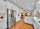Open kitchen showcasing stainless steel refrigerator and hardwood floors at 7809 S Flower St, Littleton, CO 80128