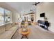 Open-concept living room with a large window, vaulted ceilings, and views into the kitchen and dining areas at 7809 S Flower St, Littleton, CO 80128