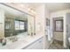 Bright primary bathroom with double sinks, a frameless mirror, a bathtub, and a glass shower at 8300 Fairmount Dr # M103, Denver, CO 80247