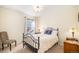 Cozy bedroom with a wrought iron bed, bedside tables, and a comfortable armchair, creating a warm and inviting atmosphere at 8300 Fairmount Dr # M103, Denver, CO 80247
