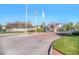 Pelican Pointe community entrance showcasing brick signage, flags, stone guard house, and manicured landscaping, providing a secure welcome at 8300 Fairmount Dr # M103, Denver, CO 80247