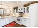 Well-lit kitchen featuring white cabinets, stone backsplash, stainless appliances and modern fixtures at 8300 Fairmount Dr # M103, Denver, CO 80247