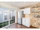 Modern kitchen with stainless steel fridge, white cabinets, and sliding glass door to outdoor patio at 8300 Fairmount Dr # M103, Denver, CO 80247