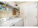 Functional laundry room with modern Maytag washer and dryer, wire shelving, and a convenient doorway at 8300 Fairmount Dr # M103, Denver, CO 80247