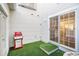 Cozy patio featuring artificial turf, ideal for outdoor grilling with a red gas grill and easy access to the home's interior at 8300 Fairmount Dr # M103, Denver, CO 80247
