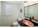 Powder bathroom features granite counter, copper sink, and a window with plantation shutters at 1892 W Kettle Ave, Littleton, CO 80120