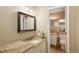 Bathroom with granite countertop, a framed mirror, and a laundry room, reflecting luxury and functionality at 1892 W Kettle Ave, Littleton, CO 80120
