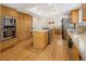 Open kitchen with stainless steel appliances, wood cabinets, and hardwood floors at 1892 W Kettle Ave, Littleton, CO 80120