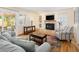 Cozy living room featuring fireplace, television, hardwood flooring, and access to the patio at 1892 W Kettle Ave, Littleton, CO 80120
