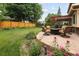 Relaxing patio area with comfortable seating around a fire pit, surrounded by lush greenery and vibrant flowers at 1892 W Kettle Ave, Littleton, CO 80120