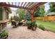 Charming patio with a wooden pergola, cozy seating, and a view of the well-manicured lawn and surrounding greenery at 1892 W Kettle Ave, Littleton, CO 80120