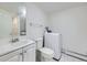 Bright bathroom featuring a toilet, sink, and a convenient washing machine for added functionality at 10895 Fairfax Way, Thornton, CO 80233