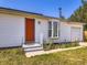 Exterior featuring white siding, an orange front door, and an attached garage at 10895 Fairfax Way, Thornton, CO 80233