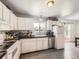 Bright kitchen features white cabinets, modern appliances, and a view of the backyard at 10895 Fairfax Way, Thornton, CO 80233