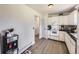 Well-lit kitchen with white cabinets, mosaic backsplash, and modern vinyl flooring at 10895 Fairfax Way, Thornton, CO 80233