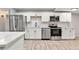 Modern kitchen featuring stainless steel appliances, white cabinetry, and hardwood flooring at 13605 E 13Th Ave, Aurora, CO 80011