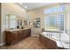 Relaxing bathroom with a soaking tub, dual sinks, and a glass-enclosed shower at 744 Kryptonite Dr, Castle Rock, CO 80108