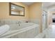 Luxurious bathroom with marble-tiled tub and large soaking tub next to a glass shower at 744 Kryptonite Dr, Castle Rock, CO 80108