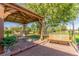 Landscaped backyard featuring a covered patio dining set and a cozy wooden swing at 833 Applewood Dr, Lafayette, CO 80026