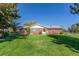 Classic brick ranch home featuring a well-manicured green lawn and charming front garden at 833 Applewood Dr, Lafayette, CO 80026