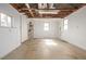 Unfinished garage with concrete floor, windows, and exposed ceiling at 833 Applewood Dr, Lafayette, CO 80026