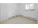 Empty room featuring a window and light tile floors with a heater at 833 Applewood Dr, Lafayette, CO 80026