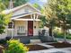 Inviting single-story home with a covered front porch with seating and lovely landscaped front yard at 4955 Julian St, Denver, CO 80221