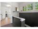 Bright hallway features wood floors, white trim, and charming window views of surrounding greenery at 4955 Julian St, Denver, CO 80221
