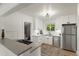 Bright kitchen featuring stainless appliances, white cabinetry, stone countertops, and neutral decor at 4955 Julian St, Denver, CO 80221