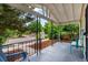 Relaxing covered front porch with seating, wrought iron railing, and views of the lush, tree-lined street at 4955 Julian St, Denver, CO 80221
