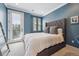 Bedroom featuring blue walls, carpet flooring, a large window and a door leading to the outside at 7814 Inverness Blvd, Englewood, CO 80112