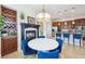 Open dining area with fireplace, wine storage, and a view into a modern kitchen with breakfast bar at 7814 Inverness Blvd, Englewood, CO 80112
