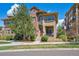 Charming townhome with a red door, covered porch, and landscaped front yard on a sunny day at 7814 Inverness Blvd, Englewood, CO 80112