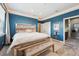 Stunning main bedroom featuring blue accent wall, bench seating, and ambient cove lighting at 7814 Inverness Blvd, Englewood, CO 80112