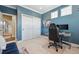 Office space with built-in closet space, blue walls, carpet flooring, and modern desk setup at 7814 Inverness Blvd, Englewood, CO 80112