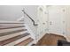 Interior view of a stairway with white risers, wood treads, and a dark metal handrail at 7814 Inverness Blvd, Englewood, CO 80112