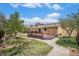 Landscaped backyard featuring a deck, stone patio, and lush plantings at 7285 S Yukon Ct, Littleton, CO 80128