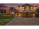 Inviting two-story home featuring a manicured lawn, two-car garage, and beautiful brick and siding accents at 7285 S Yukon Ct, Littleton, CO 80128