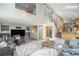 Open concept living room with vaulted ceilings, staircase, wet bar and large windows at 7285 S Yukon Ct, Littleton, CO 80128