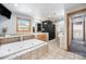 Main bathroom with shower, large soaking tub, and tile flooring at 7285 S Yukon Ct, Littleton, CO 80128