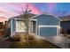 Charming home featuring a well-maintained exterior with blue siding and an attached garage at 8836 Waco Ct, Commerce City, CO 80022