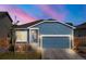 Charming blue home with a two-car garage and stone accents under a beautiful sunset sky at 8836 Waco Ct, Commerce City, CO 80022