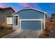 Charming blue home with a two-car garage and stone accents under a clear sky at 8836 Waco Ct, Commerce City, CO 80022