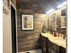 Bathroom with double vanity, updated fixtures, and decorative wood plank accent wall at 83 Wilderness Cornerstone Rd, Evergreen, CO 80439