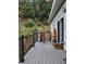 View of the house and landscaped entrance with a gray deck and a Welcome mat at 83 Wilderness Cornerstone Rd, Evergreen, CO 80439