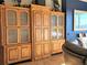 Custom built-in shelving unit with glass doors and wood finish with adjacent living room furniture at 83 Wilderness Cornerstone Rd, Evergreen, CO 80439