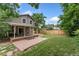 Expansive backyard features a covered patio, stone pavers, and lush greenery, perfect for outdoor relaxation and entertaining at 7120 S Clay St, Littleton, CO 80120
