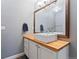 Bathroom with white vanity, wood countertop, and modern fixtures at 7120 S Clay St, Littleton, CO 80120